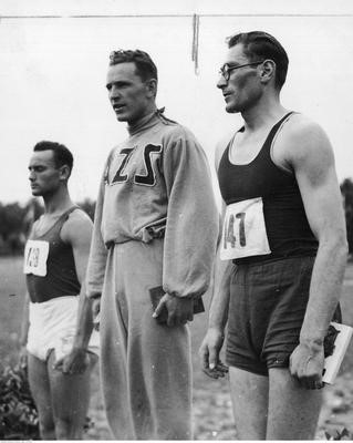 Zwycięzcy w skoku w dal w lekkoatletycznych mistrzostwach Polski w Poznaniu w 1939 r. Stoją od lewej: Jan Dziekański, Karol Hoffman, Witold Gerutto. Karol Hoffmann (ur. 10 sierpnia 1913, zm. 28 lutego 1971 w Poznaniu) – polski lekkoatleta, ośmiokrotny mistrz Polski w skoku w dal, wzwyż i trójskoku w l. 1934-1939 (czterokrotny w zawodach halowych), biegał również w sztafetach i pchał kulą. W latach 1934-1939 wystąpił w jedenastu meczach reprezentacji Polski. Był absolwentem Studium Wychowania Fizycznego Uniwersytetu Poznańskiego z 1936 r. Odtąd aż do końca kariery zawodniczej (1950) bronił barw AZS Poznań.  Zasłynął jako autor nadawanej przez Polskie Radio w l. 1946-1971 audycji „Gimnastyka poranna”, do której sam przygotowywał oryginalne zestawy prostych ćwiczeń. Zbiory NAC.